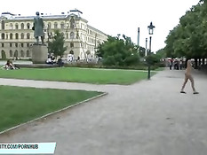 Безбашенная длинноволосая девушка гуляет по парку в голом виде