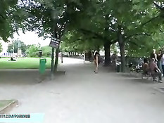 Безбашенная длинноволосая девушка гуляет по парку в голом виде
