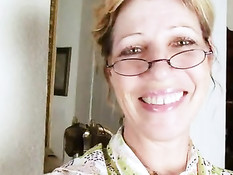 Зрелая женщина в очках раздевается и стимулирует волосатую киску